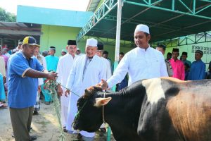 Bupati Bintan Apri Sujadi didampingin Wakil Bupati Bintan Dalmasri Syam saat menyerahkan hewan kurban di desa Busung.